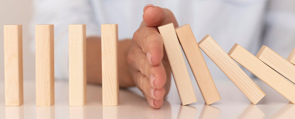 Domino-Steine werden von Hand gestoppt